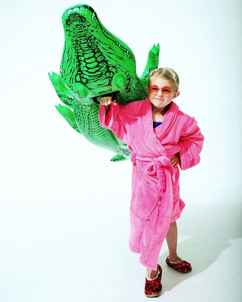Girl on white set with alligator float. Commercial studio photographer.